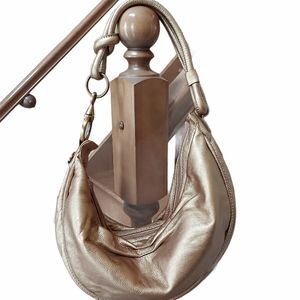 Fossil metallic gold hobo curved shoulder bag with tassel